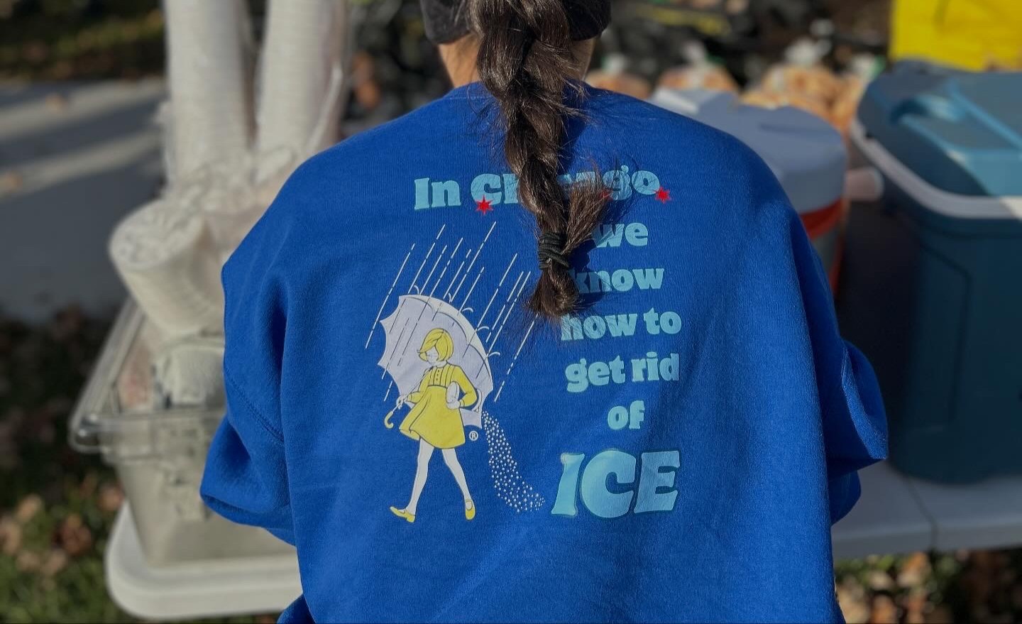 A woman's t-shirt reads "In Chicago, we kow how to get rid of ICE" as bikers take part in an event to support street vendors in Chicago, United States on Nov. 2, 2025. @cyclingxsolidarity/Handout via Thomson Reuters Foundation