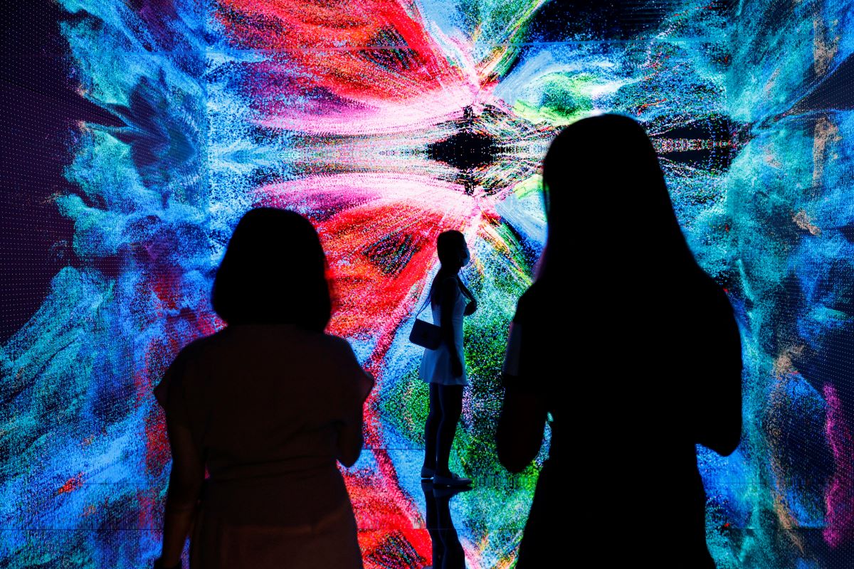 Visitors are pictured in front of an immersive art installation titled "Machine Hallucinations - Space: Metaverse" by media artist Refik Anadol, in Hong Kong, China