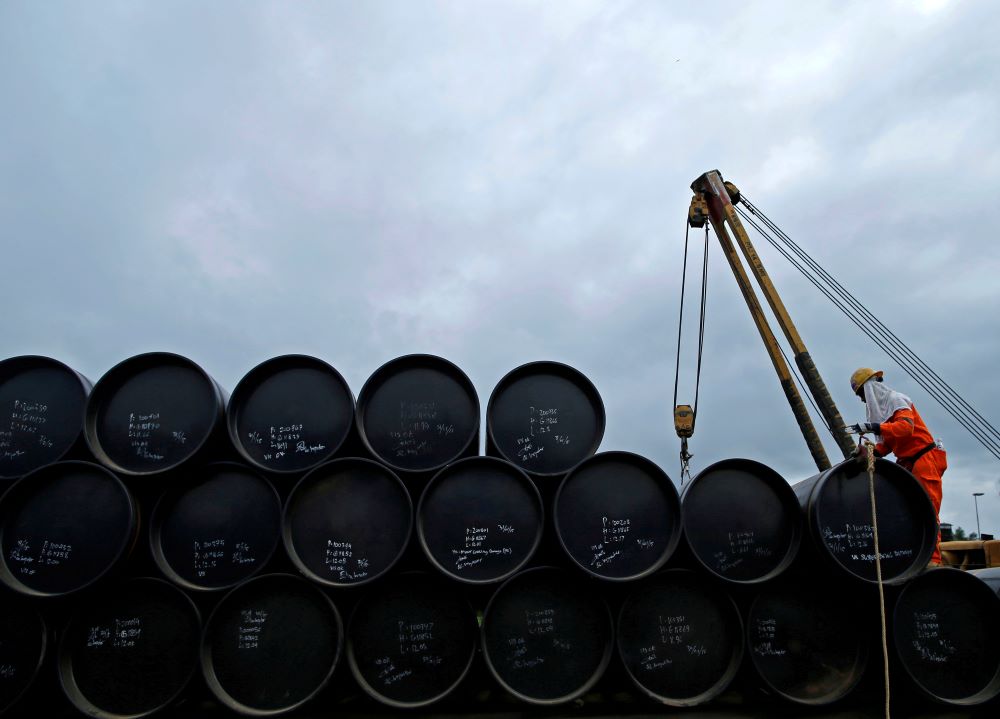 A worker prepares to transport oil pipelines to be laid for the Pengerang Gas Pipeline Project at an area 40km (24 miles) away from the Pengerang Integrated Petroleum Complex in Pengerang, Johor, February 4, 2015